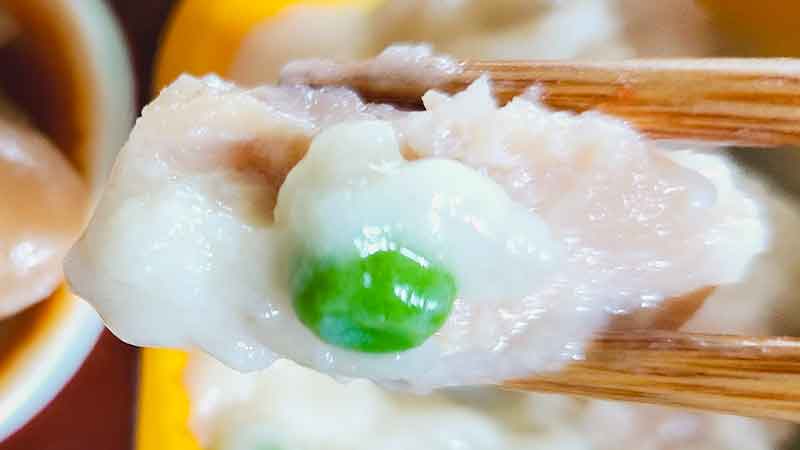 低糖質セレクトG「豚肉のスタミナ炒め」の鮭とグリンピース付を箸で持ち上げた時の写真です。