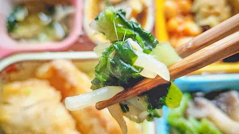 鰈の唐揚げと野菜の旨煮の副菜チンゲン菜ともやしの生姜醤油和えのチンゲン菜ともやしを箸で持ち上げた時の写真です